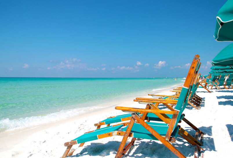 A row of chairs on a sandy beach