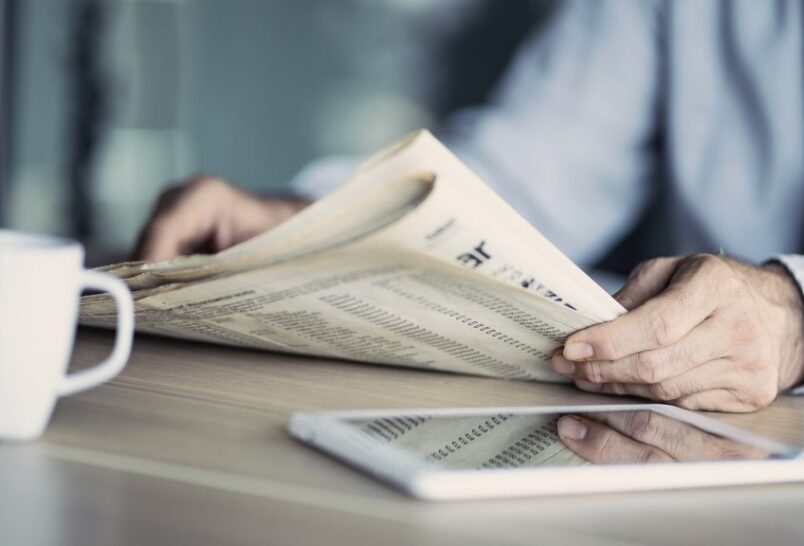 Businessman reading the newspaper on table