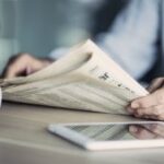 Businessman reading the newspaper on table