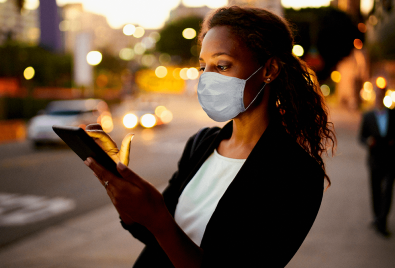 Woman wearing mask looking at tablet