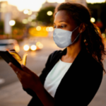 Woman wearing mask looking at tablet