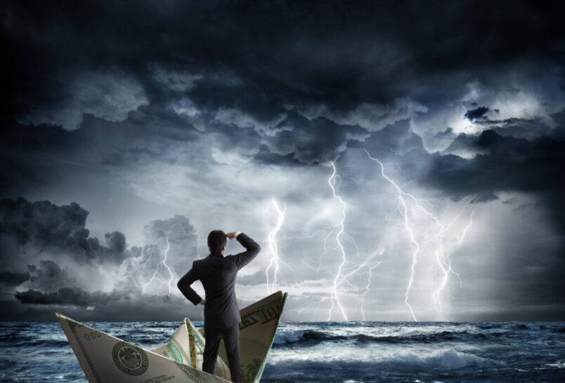 Man on a boat made of a 100 dollar bill in a storm
