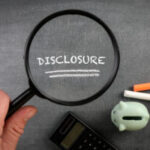 Disclosure text on chalk board under a magnifying glass