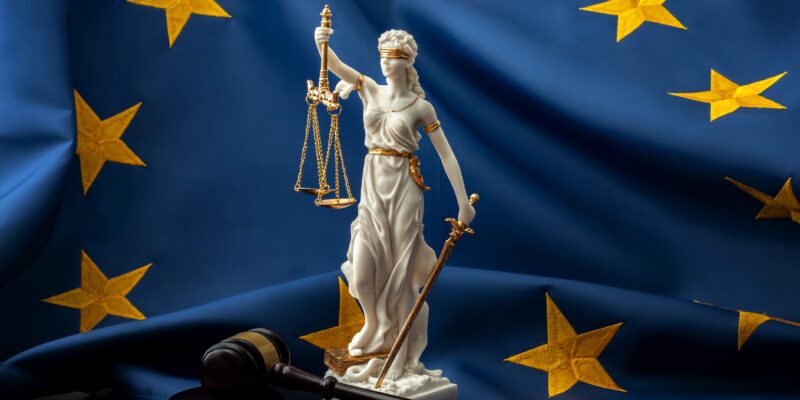 lady justice statue in front of eu flag