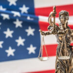 Lady Justice statue in front of american flag
