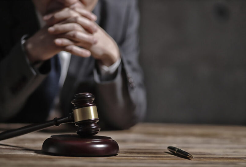 lawyer sitting at desk with a gavel and pen